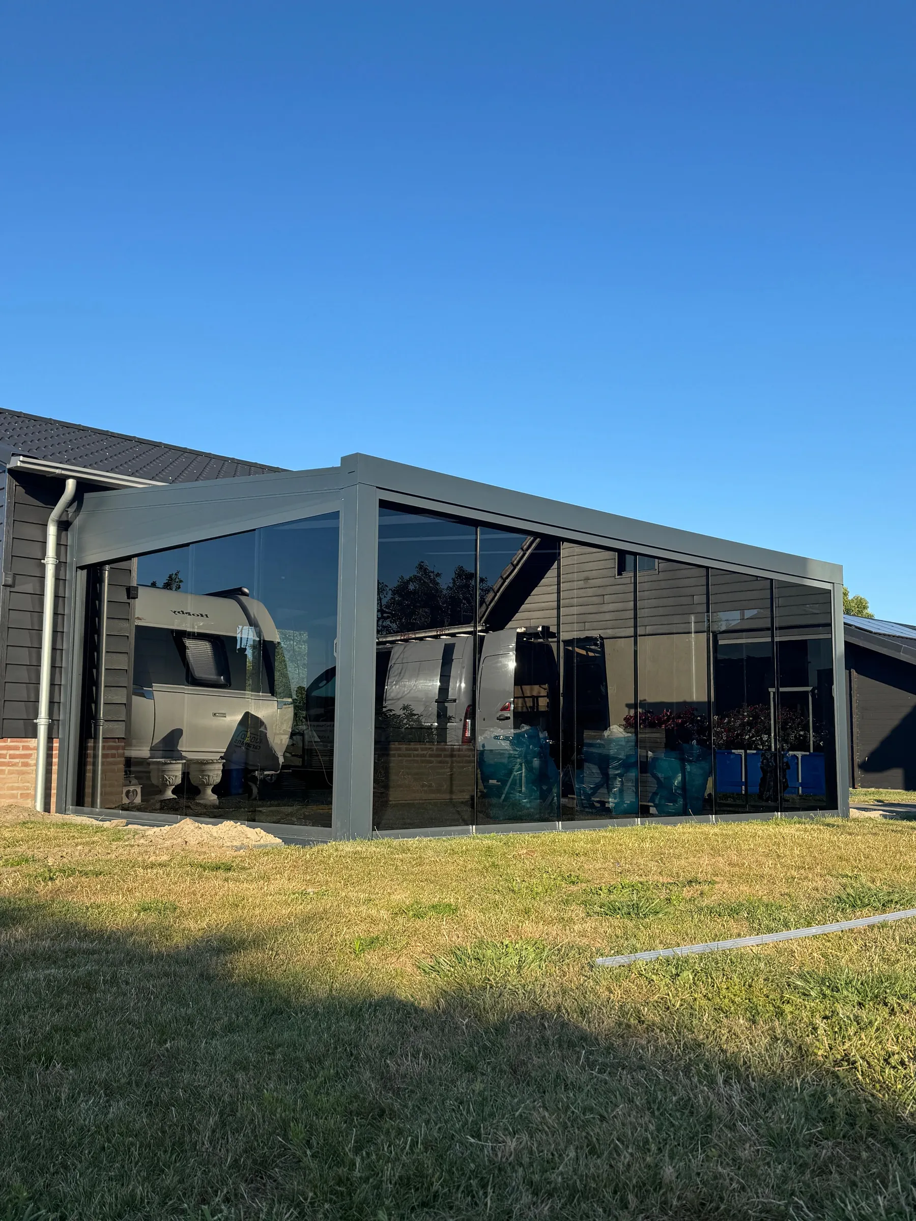 Aanbouwveranda met getinte beglazing aan een moderne woning